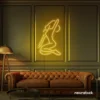 Sitting woman neon sign in golden yellow for minimalist wall art and feminine home decor.