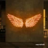 Elegant angel wings neon sign in peachy pink for wall art or restaurant decor.