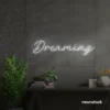 Dreaming neon sign in white for dreamy decor, teen bedrooms, and relaxing nooks.
