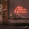 It's So Good To Be Home neon sign in peachy pink for entryways, living rooms, and cozy home decor.