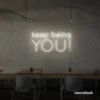 Keep Being You neon sign in neutral white for empowerment decor, teen rooms, and creative wall spaces.