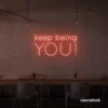 Keep Being You neon sign in peachy pink for empowerment decor, teen rooms, and creative wall spaces.