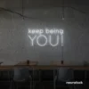Keep Being You neon sign in white for empowerment decor, teen rooms, and creative wall spaces.