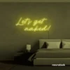 Let's Get Naked neon sign in lemon yellow for bathroom decor, cheeky bedrooms, and romantic lighting.