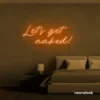 Let's Get Naked neon sign in orange for bathroom decor, cheeky bedrooms, and romantic lighting.