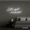 Let's Get Naked neon sign in white for bathroom decor, cheeky bedrooms, and romantic lighting.