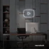 White play button neon sign on gray office wall above a modern desk