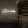 Santa Baby neon sign in neutral white for holiday parties, Christmas decor, and festive photo backdrops.