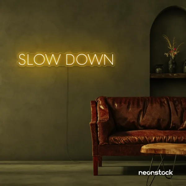 Slow Down neon sign in golden yellow for relaxation spaces, wellness decor, and mindful interiors.