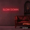 Slow Down neon sign in red for relaxation spaces, wellness decor, and mindful interiors.