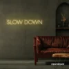 Slow Down neon sign in warm white for relaxation spaces, wellness decor, and mindful interiors.