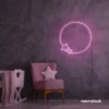 Baby pink neon sign featuring a circle and stars, glowing softly in a cozy bedroom setting.