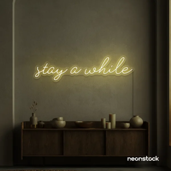 Stay Awhile neon sign in warm white for cozy cafes, home decor, and hospitality settings.