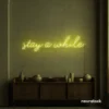 Stay Awhile neon sign in lemon yellow for cozy cafes, home decor, and hospitality settings.