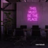 This Must Be The Place neon sign in pink for cozy salons, boutique shops, and cafe decor.