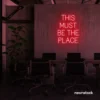 This Must Be The Place neon sign in red for cozy salons, boutique shops, and cafe decor.