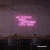 Neon sign text 'We should hang something cool here' in baby pink for wall art and home decor