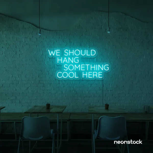 Neon sign text 'We should hang something cool here' in mint green for wall art and home decor