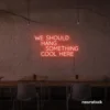 Neon sign text 'We should hang something cool here' in peachy pink for wall art and home decor