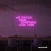 Neon sign text 'We should hang something cool here' in pink for wall art and home decor