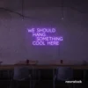 Neon sign text 'We should hang something cool here' in purple for wall art and home decor