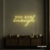 You Are Enough neon sign in warm white for self-love decor, therapy rooms, and calm spaces.